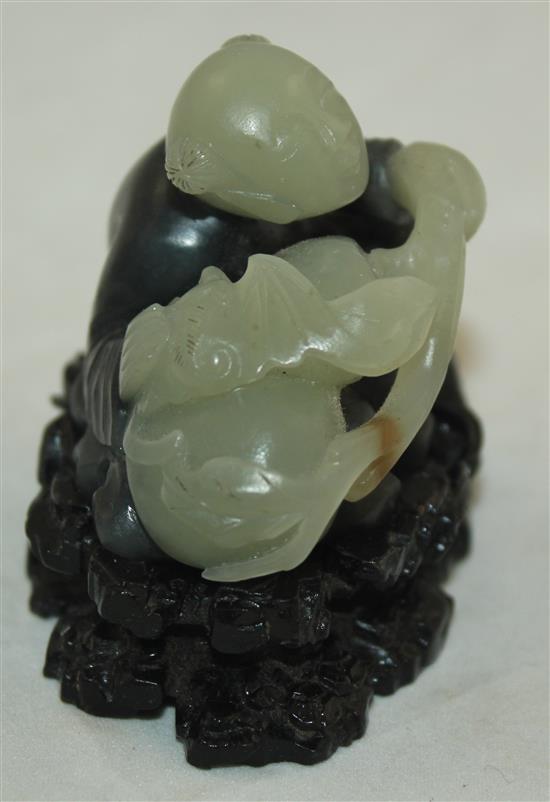 A Chinese pale celadon and dark grey jade and stand